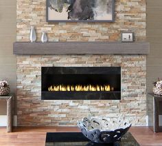 a living room with a fire place in the center and a painting on the wall