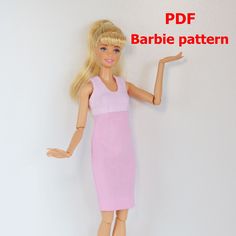 a barbie doll with blonde hair wearing a pink dress and holding her hand out to the side