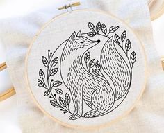 a hand embroidered hedge with leaves in the hoop on top of a piece of linen