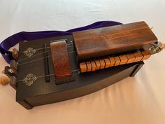 a musical instrument is sitting on top of a purple case with strings attached to it