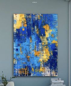 a blue and yellow painting hanging on the wall