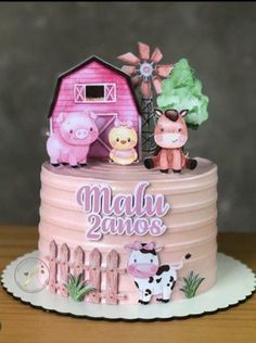 a pink cake with farm animals on top