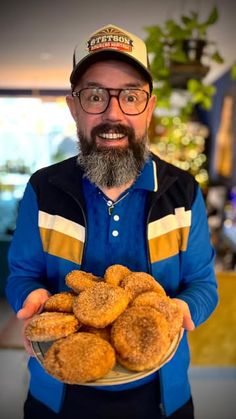 a man holding a plate full of doughnuts