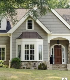 a gray house with white trim and brown door