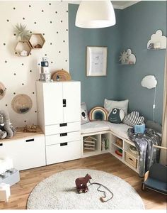 a child's room with blue walls and white furniture