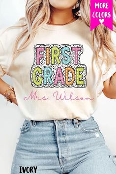 a woman wearing a t - shirt with the words first grade on it