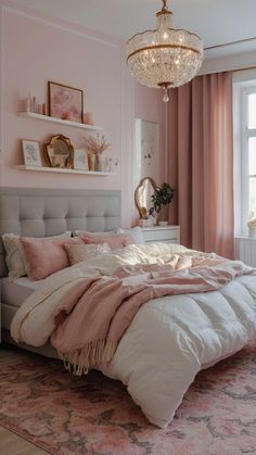 a bedroom with pink walls, white bedding and a chandelier hanging from the ceiling