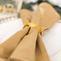 a close up of a napkin on a plate with a gold ring in the middle