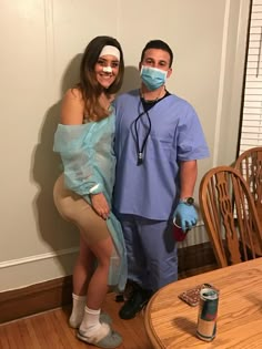 a man and woman in scrubs standing next to each other near a dining room table