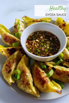 a white plate topped with food and dipping sauce