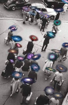 an aerial view of people holding umbrellas in the street