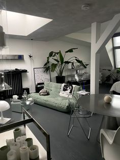 a living room filled with furniture next to a window and potted plant on top of a table