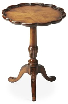 a wooden table with an ornate design on the top and legs, sitting against a white background