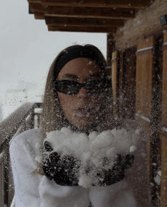 a woman blowing snow in front of her face