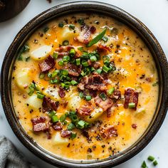 a bowl of potato soup with bacon and green onions