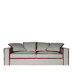 a white couch with red piping and pillows on it's backrests