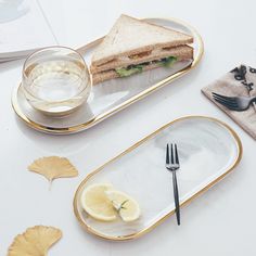 a plate with a sandwich on it next to a glass of water and a fork