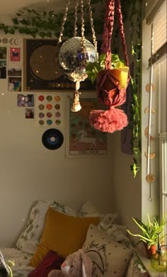 a living room filled with lots of plants and decorations on the wall next to a window