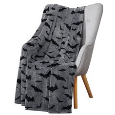 a gray and black bat print blanket sitting on top of a chair