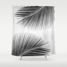 an abstract shower curtain with black and white palm leaves on the outside, against a gray background