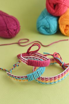 three balls of yarn are sitting next to each other on a table with crochet hooks