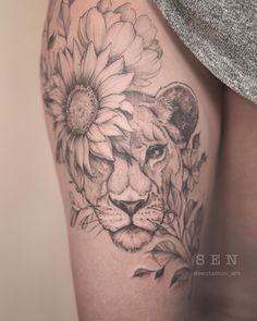 a woman's thigh with a lion and flowers on it