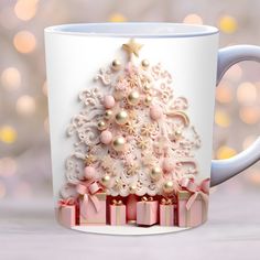 a white coffee mug with a pink christmas tree on the side and presents under it