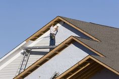 a man working on the roof of a house