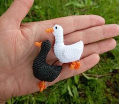 a small crocheted duck and goose on someone's hand