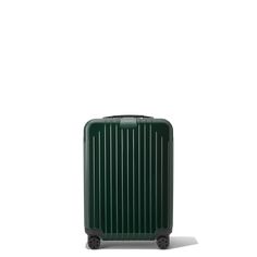 a green suitcase sitting on top of a white floor