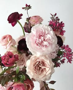 a vase filled with lots of pink and red flowers