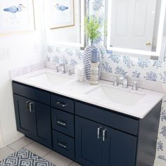 a blue and white bathroom with double sinks