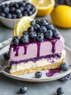 a slice of blueberry cheesecake on a plate with lemons and blueberries