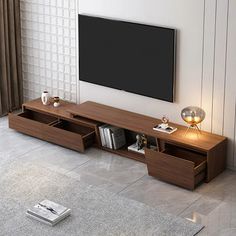 a living room with a large flat screen tv mounted on the wall and two drawers below it