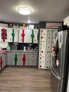 a kitchen decorated for christmas with white cabinets and silver appliances