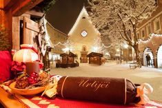 a christmas display in front of a church with lights on the trees and decorations around it