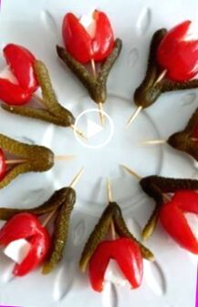 a white plate topped with red flowers and toothpicks