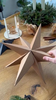 a person is holding a paper star on a table