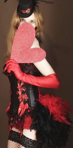 a woman in a corset with a heart on her chest and hat over her head