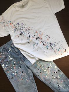 a pair of jeans and t - shirt with paint splattered on them