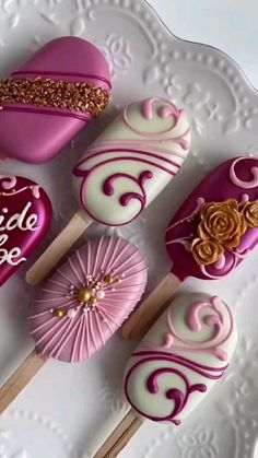 pink and white desserts are arranged on a plate with gold glitter trim around them