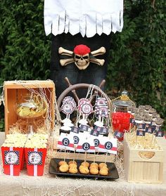 a pirate themed dessert table with snacks and treats on the table, along with an image of a skeleton