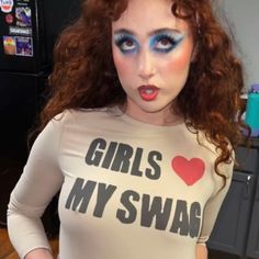 a woman with red hair and makeup is wearing a t - shirt that says girls my swag