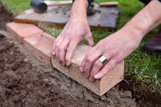 a man is placing bricks in the ground