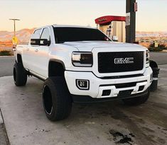 a white truck parked in front of a gas station