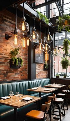 an empty restaurant with green booths and hanging plants on the wall, along with wooden tables