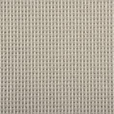 an upholstered fabric textured with small squares in beige and white colors, closeup