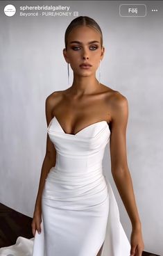 a woman in a white dress posing for the camera