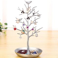 a silver tree with jewels in it on a table