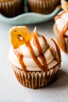 cupcakes with caramel drizzled on top and bananas in the background